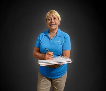 Alice Perry in a blue shirt holding a caller information form