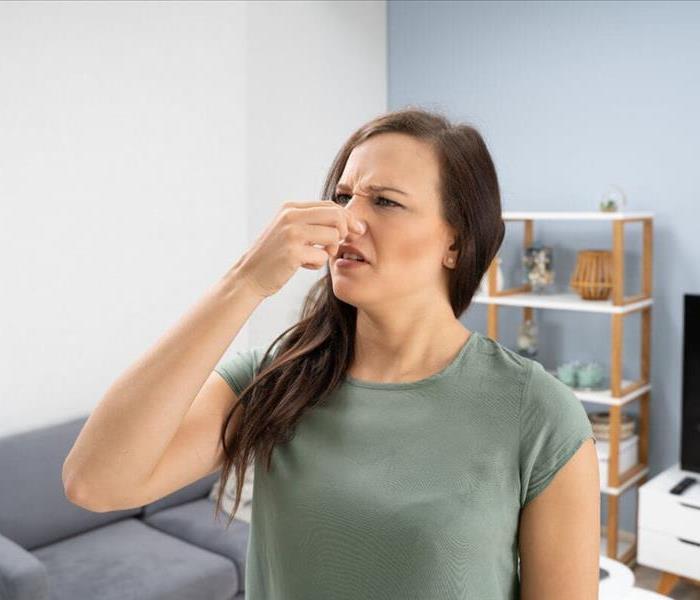 woman pinching nose because of a bad smell